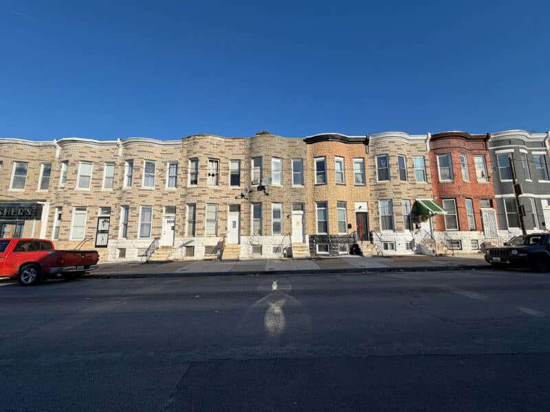 Row of two-story brick townhomes along West Lafayette Avenue in Baltimore City