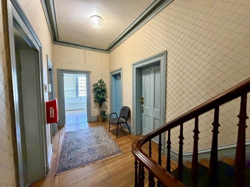 Upper-level hallway and staircase at Historic McCabe Mansion commercial building