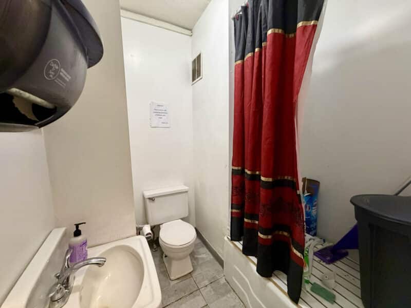Bathroom with shower, toilet, and sink inside McCabe Mansion commercial building in Baltimore Maryland