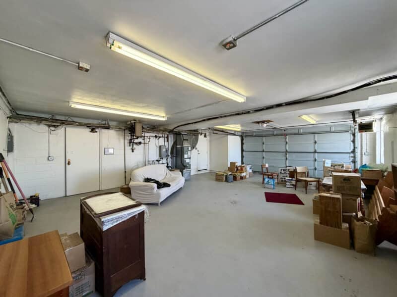 Large garage or storage area with overhead lighting at McCabe Mansion commercial property
