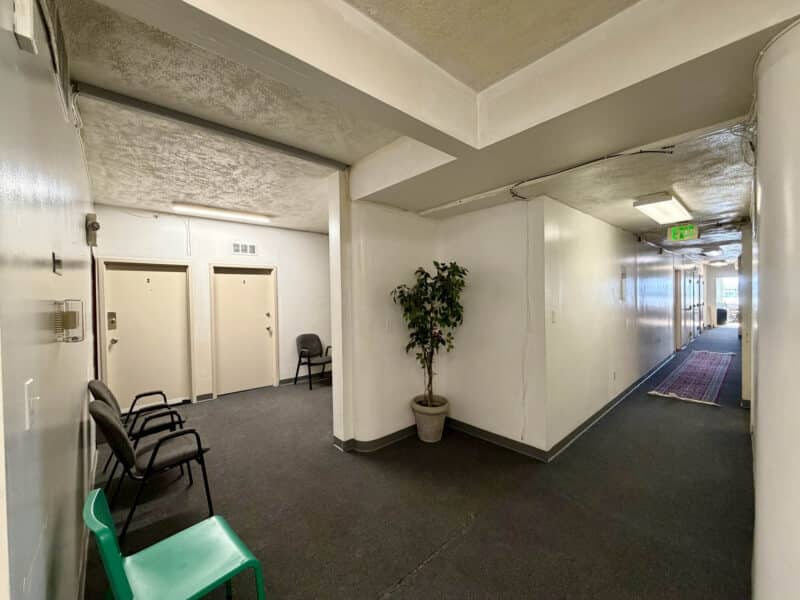 Interior hallway with waiting chairs and common access doors inside McCabe Mansion Baltimore