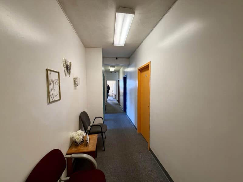 Long interior hallway with office entrances and waiting area seating at McCabe Mansion