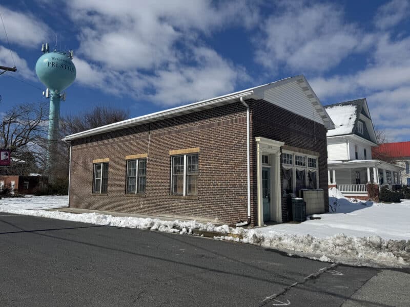 Side perspective of brick commercial building at 160 Main Street Preston MD with Preston water tower visible