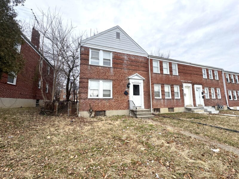 Angled exterior view of 5516 Midwood Avenue showing end-of-group position and adjacent rowhomes