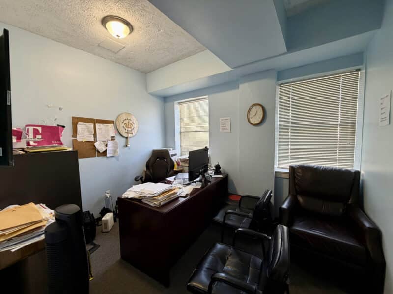 Private office with desk, leather chairs, and windows inside McCabe Mansion Baltimore