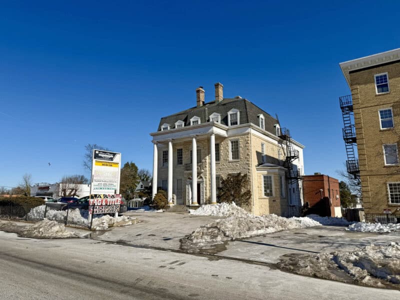 Wide street view of Historic McCabe Mansion at corner of York Road and McCabe Avenue