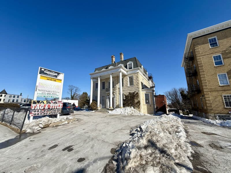 Street-level view of historic stone commercial building along York Road corridor with surrounding properties.