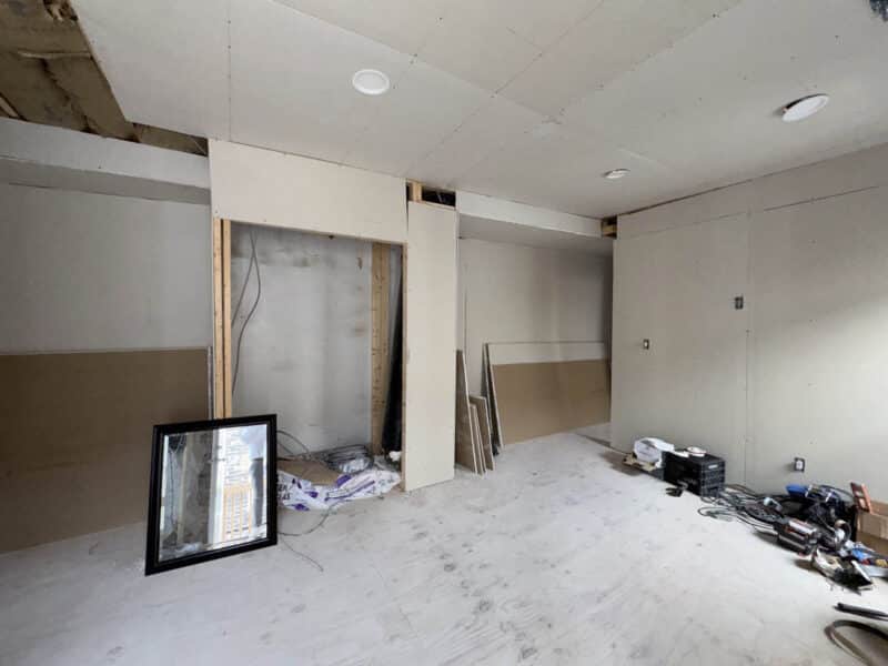 Partially finished interior space with drywall, recessed lighting, and open layout in mixed-use building
