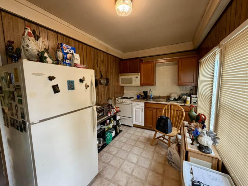 Kitchen with refrigerator, electric stove, wood cabinetry, and window at 8226 Fort Smallwood apartment unit