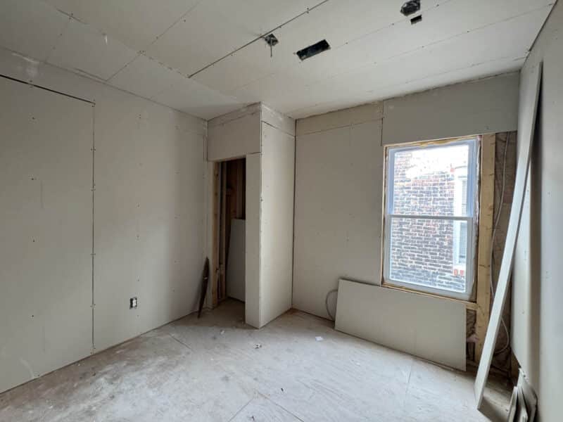 Partially finished room with drywall, window, and closet opening in renovated property