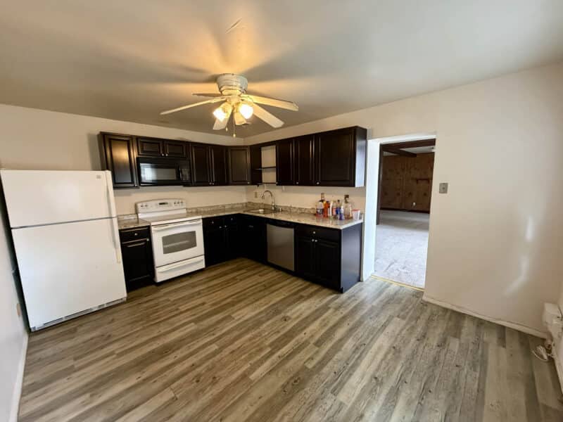 Updated kitchen with dark cabinets, granite countertops, and appliances in converted barn at 8226 Fort Smallwood