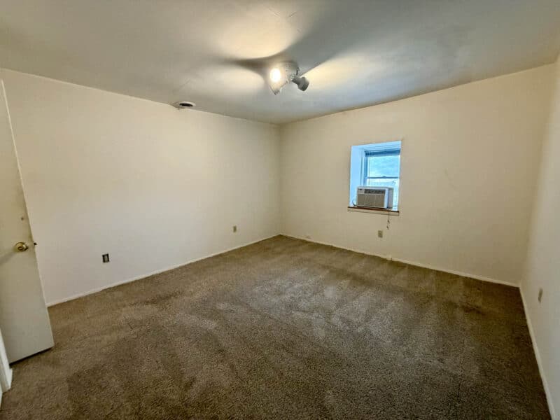 Bedroom with window AC unit and carpet flooring in converted barn unit at 8226 Fort Smallwood Road