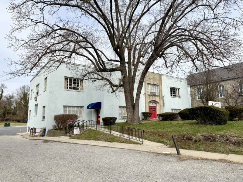 Adjacent building with entrance and mature tree near church property on Belair Road