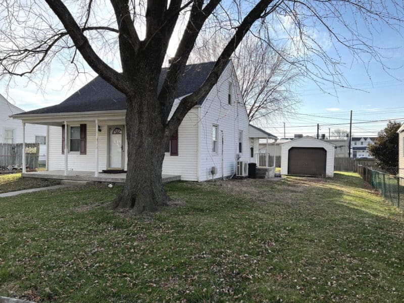 Front yard with mature tree and detached garage at 54 Riverside Road Essex Maryland