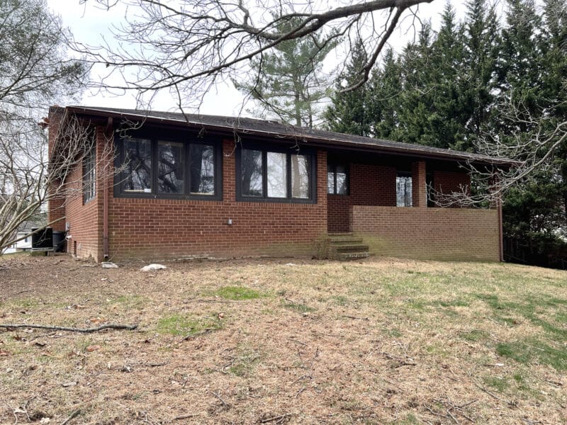 Rear exterior of brick rancher with sunroom and large yard in Ellicott City
