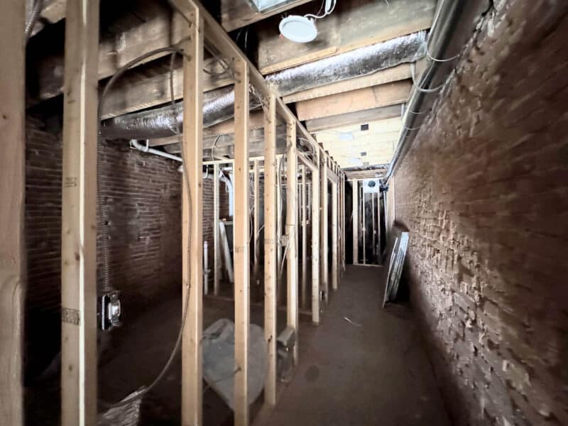 Framed interior corridor in commercial building with exposed brick and unfinished construction