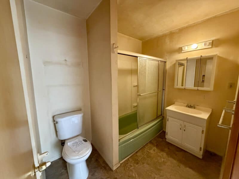 Bathroom with tub-shower combination, vanity, and overhead lighting