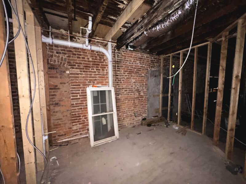 Interior framing and exposed brick walls in unfinished commercial unit