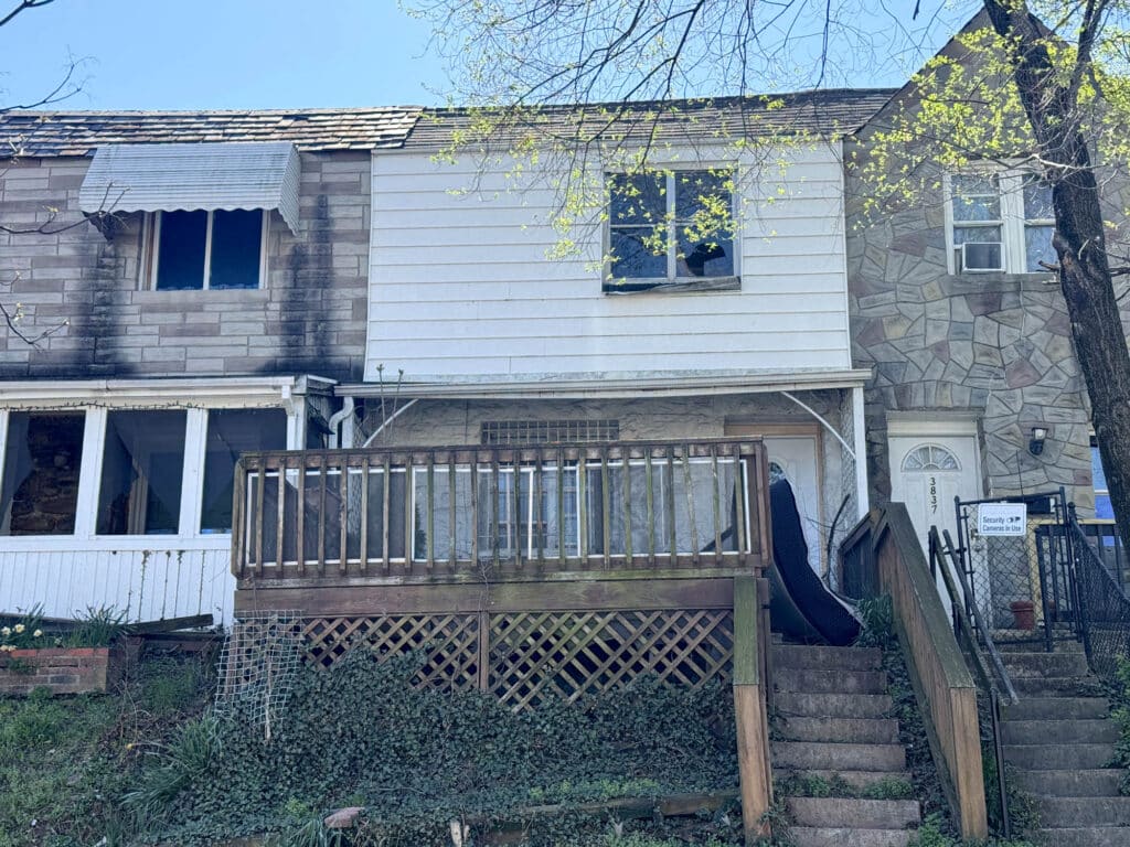 Two story Baltimore townhome with raised front deck and stairs in Brooklyn neighborhood