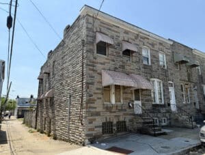 End-of-group brick townhome at 1631 Church Street in Curtis Bay Baltimore with side access and stone façade