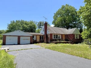 Front exterior of brick traditional home with attached two-car garage on a 0.87± acre lot in Bel Air, Maryland.