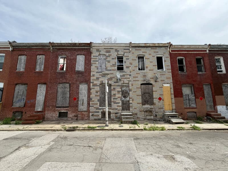 Row of boarded Baltimore townhomes on N Chapel Street Broadway East