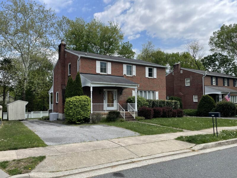 Angled exterior view showing driveway and side yard of brick home in Perry Hall