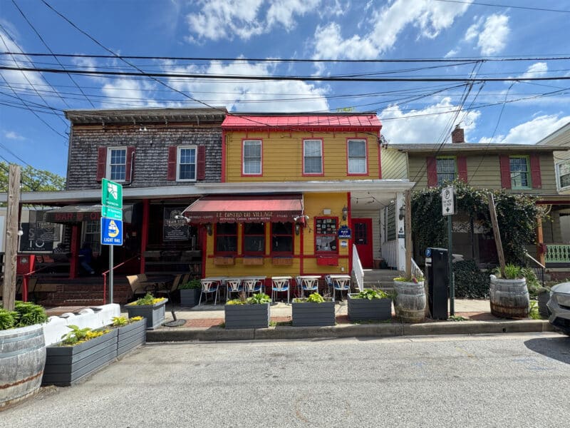 Street view of Le Bistro Du Village restaurant with outdoor dining seating in Mount Washington Baltimore