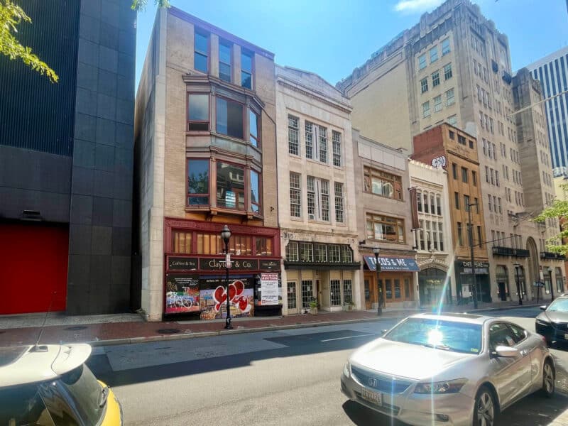 Angled view of multi-story storefront buildings along North Charles Street in Downtown Baltimore commercial corridor