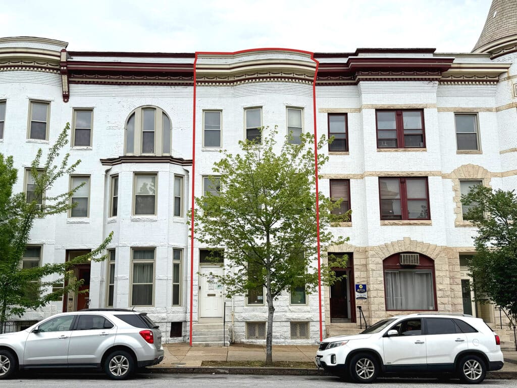 Three-story brick commercial building at 116 E. 25th Street in Charles Village, Baltimore, Maryland.