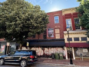 Front exterior of 893-895 N. Howard Street, two adjoining three-story brick storefront buildings in Baltimore's Antique Row district.