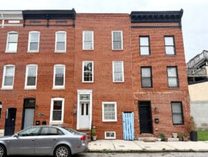 Front exterior of three-story brick townhome at 1447 William Street in Riverside featuring historic Federal Hill architecture.