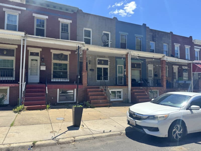 Street view of attached brick rowhomes on North Ellwood Avenue in East Baltimore