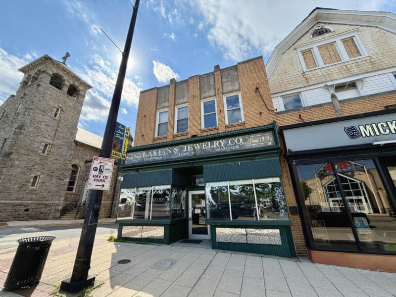 Exterior storefront view of 5400 Harford Road, formerly occupied by Lakein’s Jewelers, featuring display windows and brick façade construction.