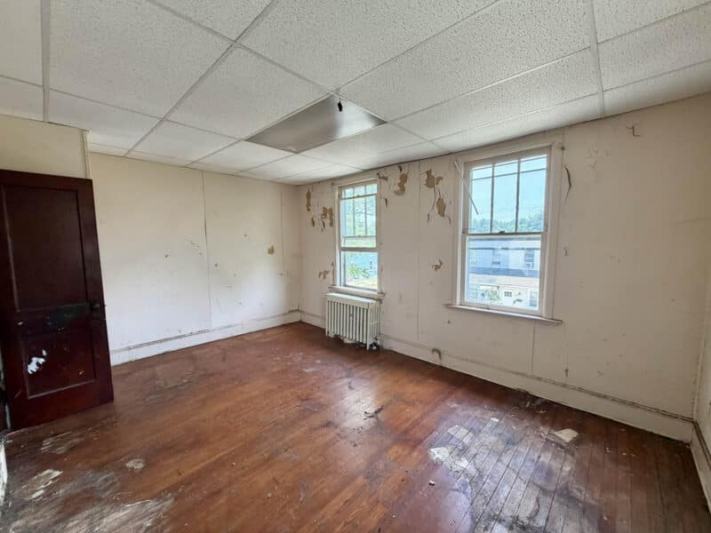 Front bedroom with hardwood flooring and two windows at 238 Baltimore Avenue in Dundalk