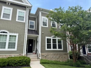 Front exterior of 6308 Canter Way in the Woodbrook on Charles Condominium community featuring attractive architecture, landscaped grounds and end-of-group townhouse design.