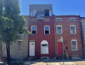 Front exterior of 1121 W. Lombard Street, a three-story shell townhome in Baltimore's Hollins Market neighborhood.