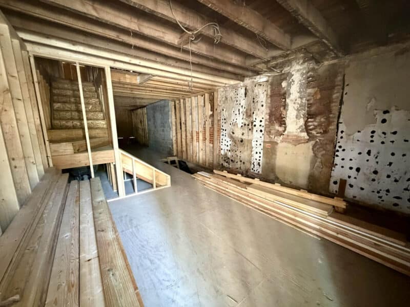 Framed interior space with exposed beams and construction progress at 1121 W. Lombard Street.