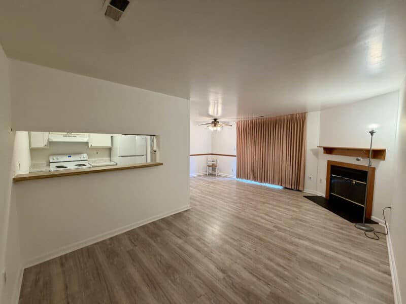 Open living room with fireplace and kitchen pass-through window in Glen Burnie condominium unit