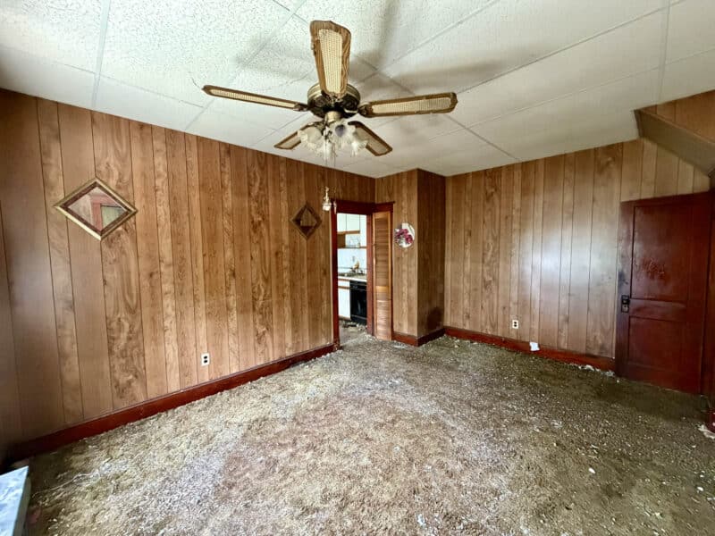 Living room with ceiling fan and wood-paneled walls at 238 Baltimore Avenue