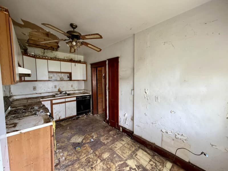 Kitchen with existing cabinetry and ceiling damage in Saint Helena Dundalk townhome