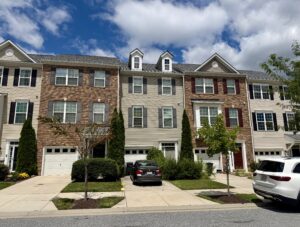 Front exterior of 9544 John Locke Way, a three-story townhouse with garage in Ballard Green, Owings Mills, MD