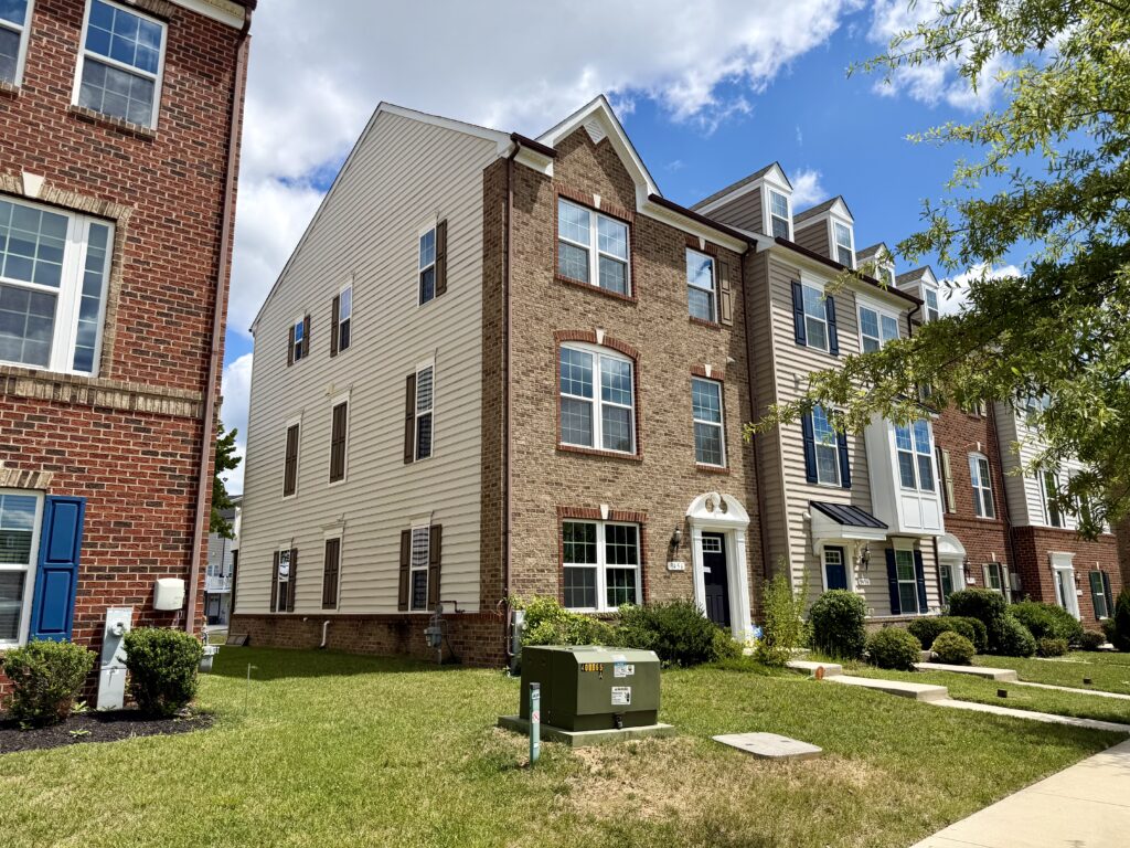 Front and side exterior of 9456 Ballard Green Drive, an end-of-group townhouse in Owings Mills, MD