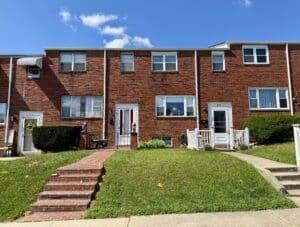 Front exterior of two-story brick townhome at 959 Regina Drive in Maiden Choice Village, Arbutus, Maryland.