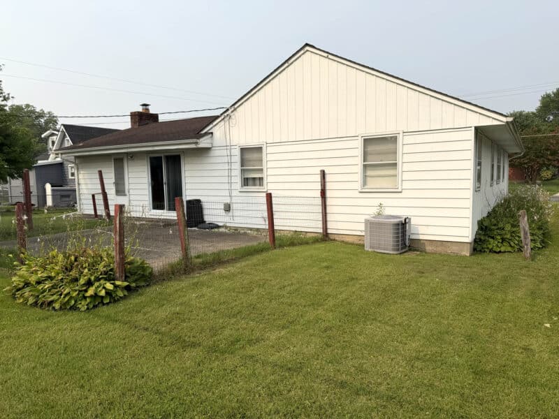Rear exterior of ranch home with concrete patio and backyard at 8327 Old Harford Road in Parkville, Maryland