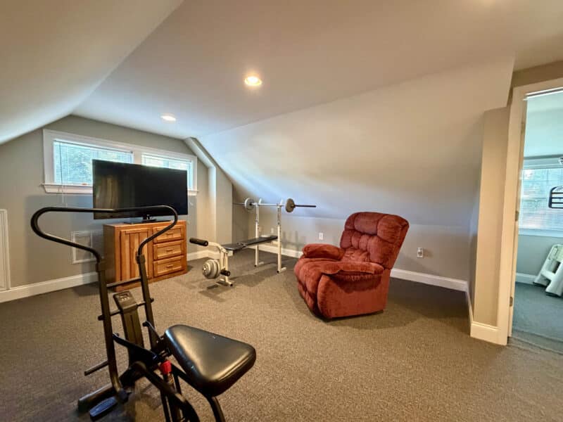 Finished upper-level room with carpeting, recessed lighting, windows and sloped ceilings.