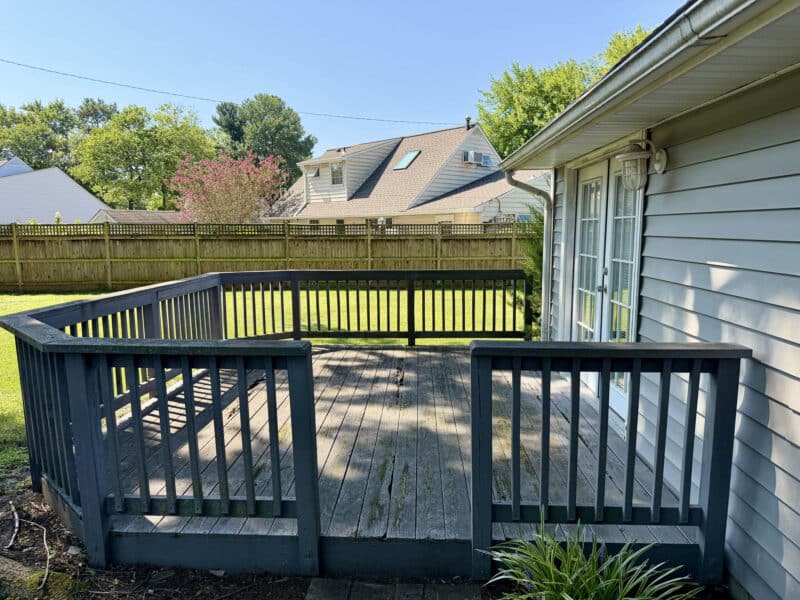 Wooden rear deck overlooking the backyard of Cape Cod home.