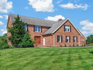 Front exterior view of large two-story brick residence with attached garage and landscaped lawn