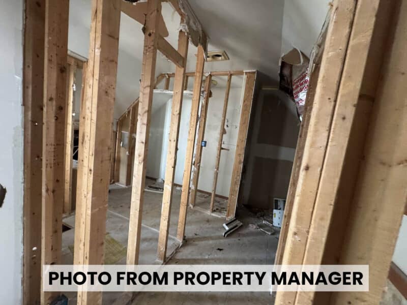Partially demolished interior at 4900 Curtis Avenue featuring exposed wooden wall studs, unfinished partitions, and damaged ceiling finishes.