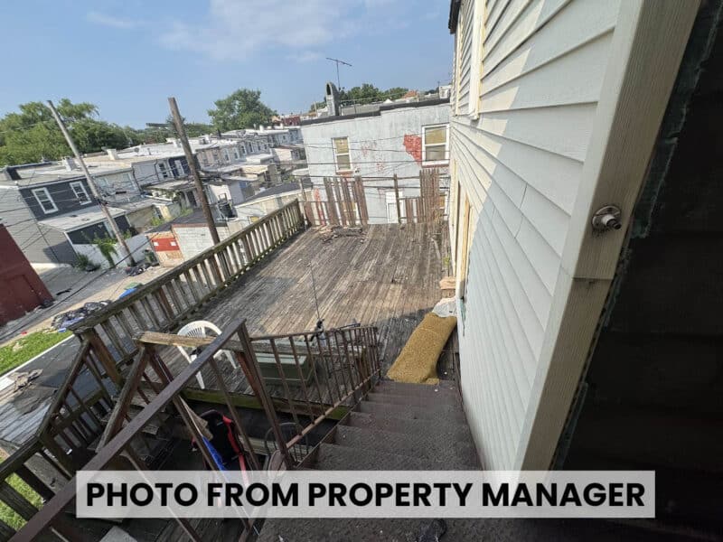 Elevated wooden exterior deck at 4900 Curtis Avenue in Curtis Bay overlooking neighboring Baltimore rowhomes and rear alley.